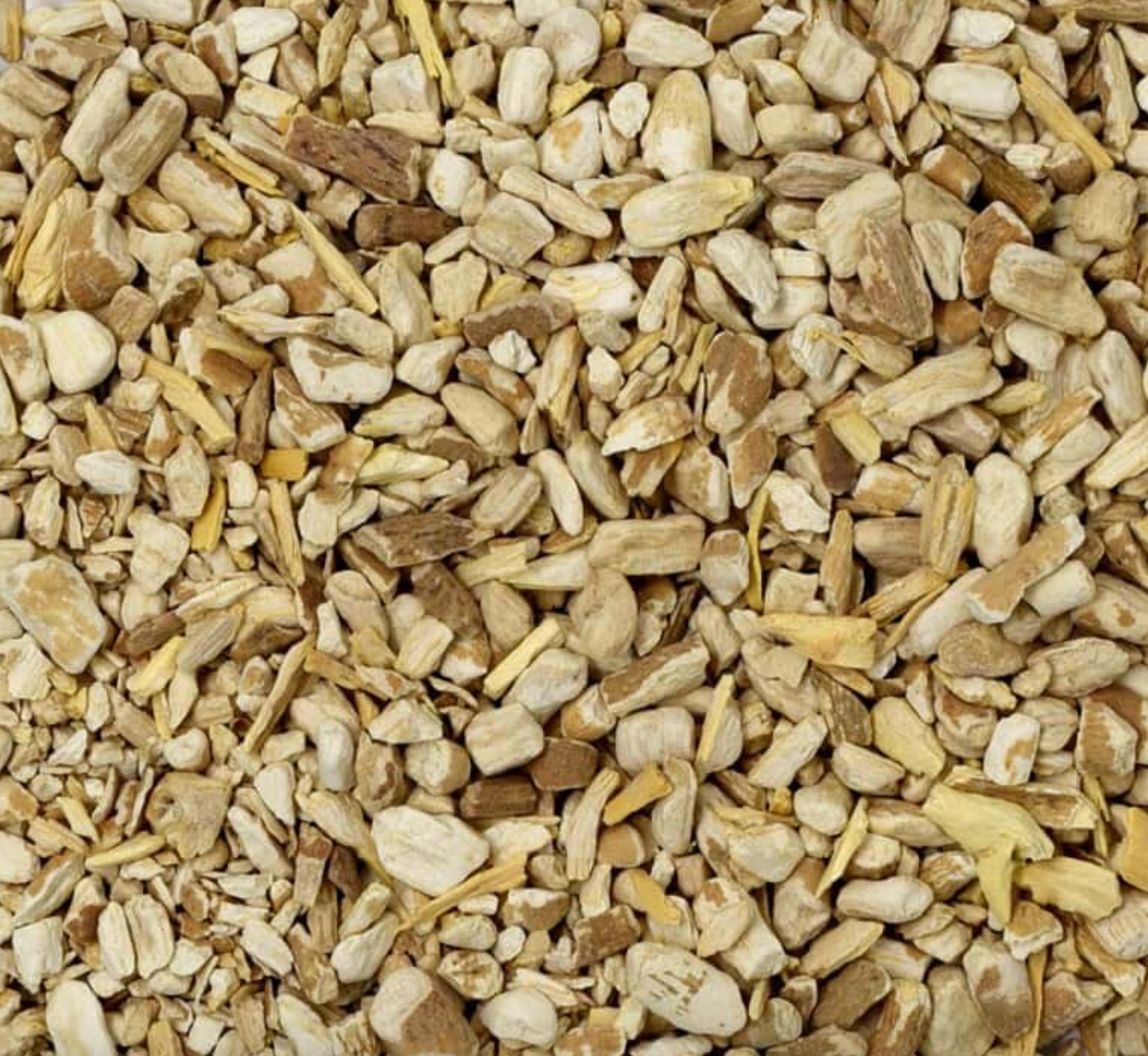 Close-up texture of dried ashwagandha root, showing small beige pieces used for teas and herbal remedies.